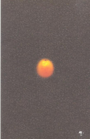 Une orange roulant sur le sol d'un parking et s'illuminant tranquillement de toutes les couleurs de